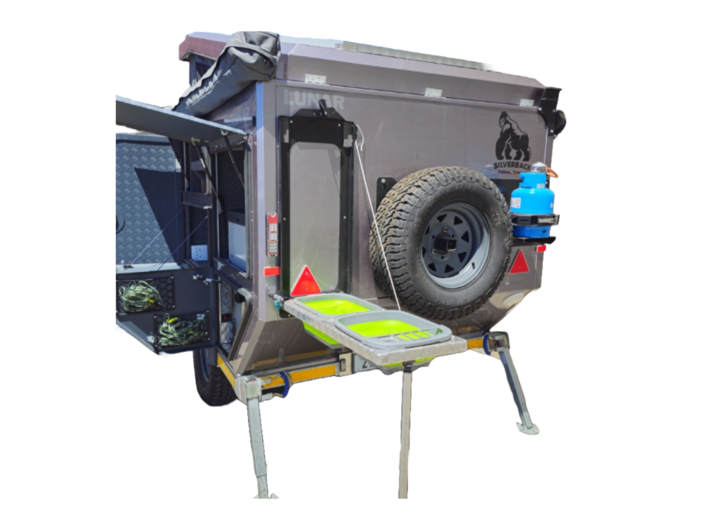 Rear of the Lunar camper with the dishwashing station folded out, spare wheel and gas bottle mounted